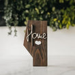 Load image into Gallery viewer, The Alberta board stands 10.5 inches tall and 1.5 inches thick it is made from solid Pine with a smooth walnut stain and protective topcoat finish with the option of raised 'Home' lettering
